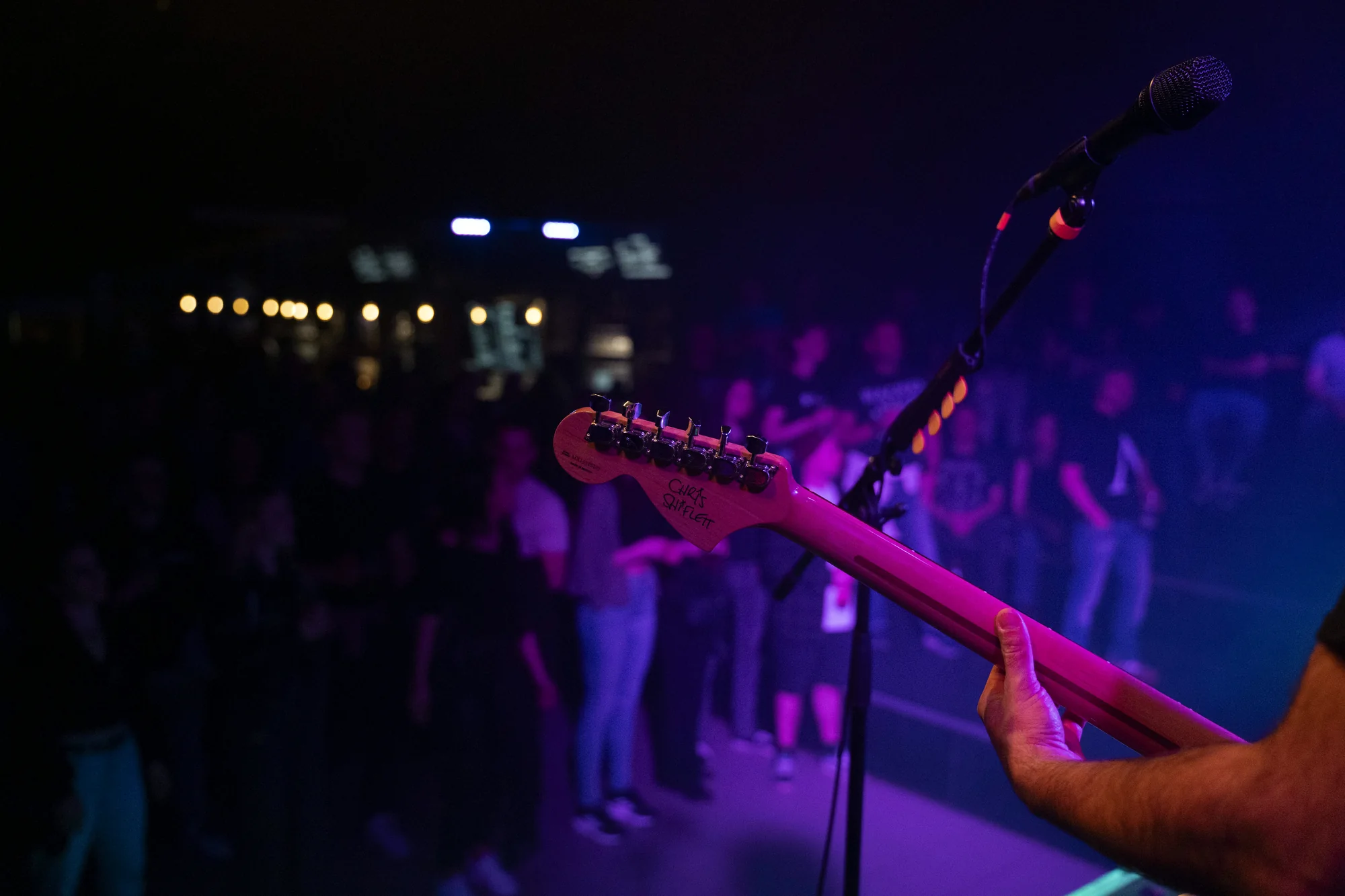 Blick über einen Gitarrenhals ins Publikum